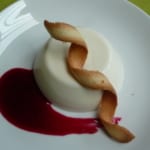 An image of vanilla cream with black currant coulis and tuille twils