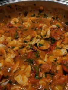 A pan of prawns cooked with tomatoes and garlic
