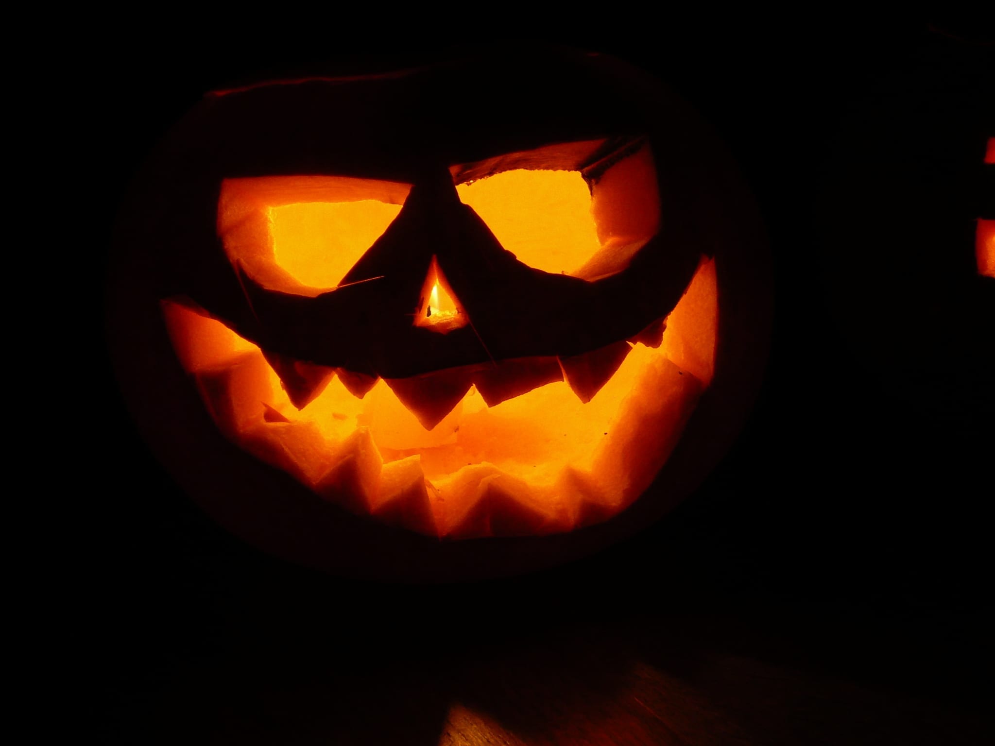 A pumpkin lantern glowing in the dark