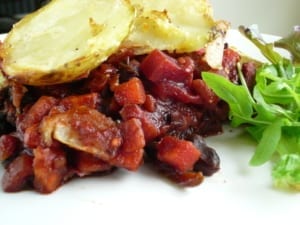 mixed red vegetables cooked with adzuki beans topped with crispy potato slices