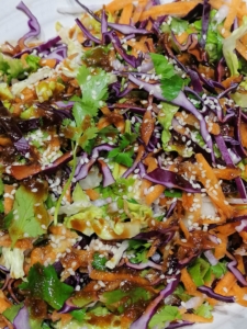 A bowl of finely sliced red cabbage tossed with daikon radish, carrot, gem lettuce & soy ginger dressing