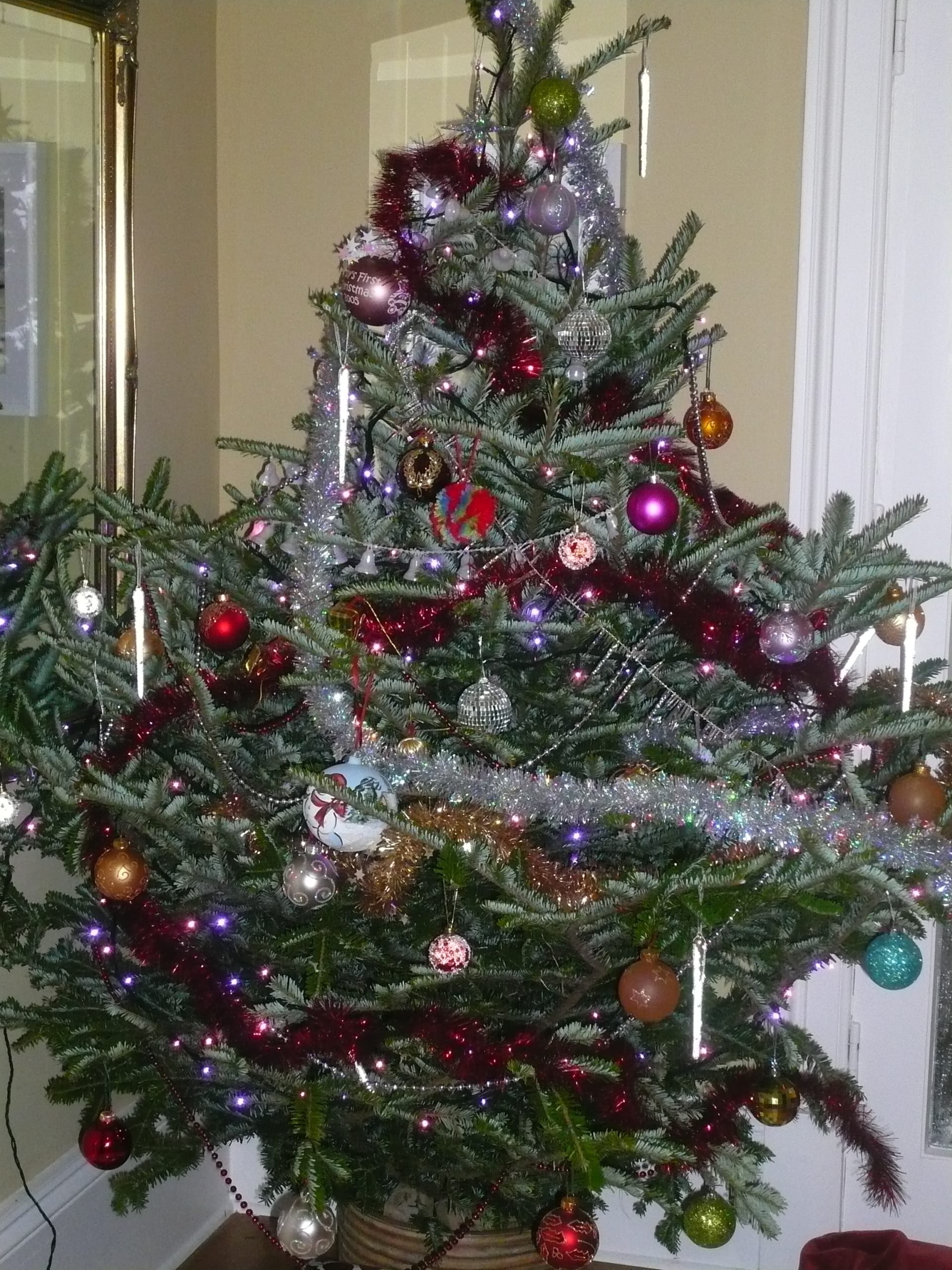 A Christmas tree decorated with baubles, tinsel and lights