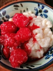 A bowl of rice pudding with raspberry compote