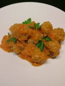 A dish of pork meatballs with fresh tomato sauce