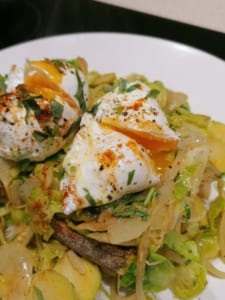 A dish of poached eggs served on toast with steam fried mustard sprouts