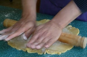 An image of someone's hands rolling out pastry