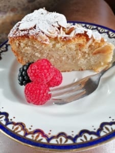 an image of a piece of apple cake served with raspberries and brambles
