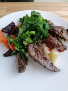 An image of liver served with mash, roast veg and greens