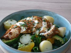A dish of Charmoula roasted chicken with a kale and potato salad