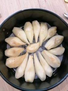 An image of pear quarters arranged around the bottom of a cake tin