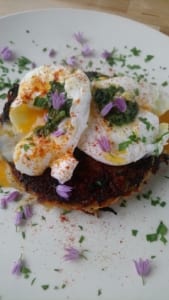 An image of vegetable rosti served with poached eggs and herb butter