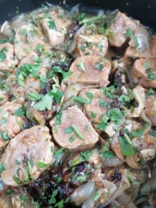 An image of a pan of sweet and sour pork fillet with orange & prunes