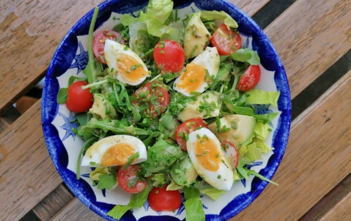 A bowl of avocado and soft boiled egg salad