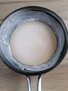 A flour dusted frying pan with a little batter in the bottom