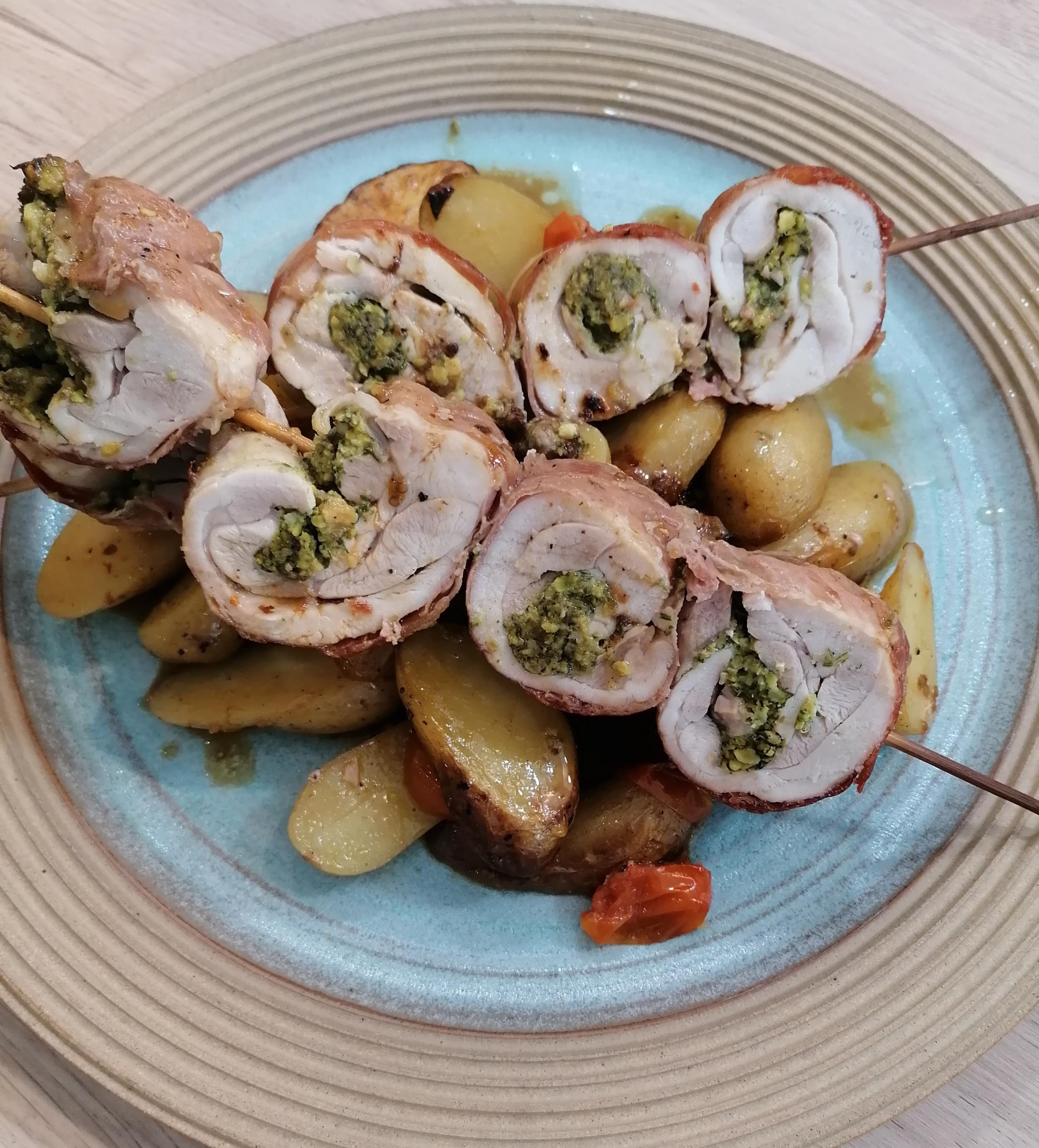 an image of chicken skewers stuffed with pistachio nuts & herbs, served on a bed of new potatoes